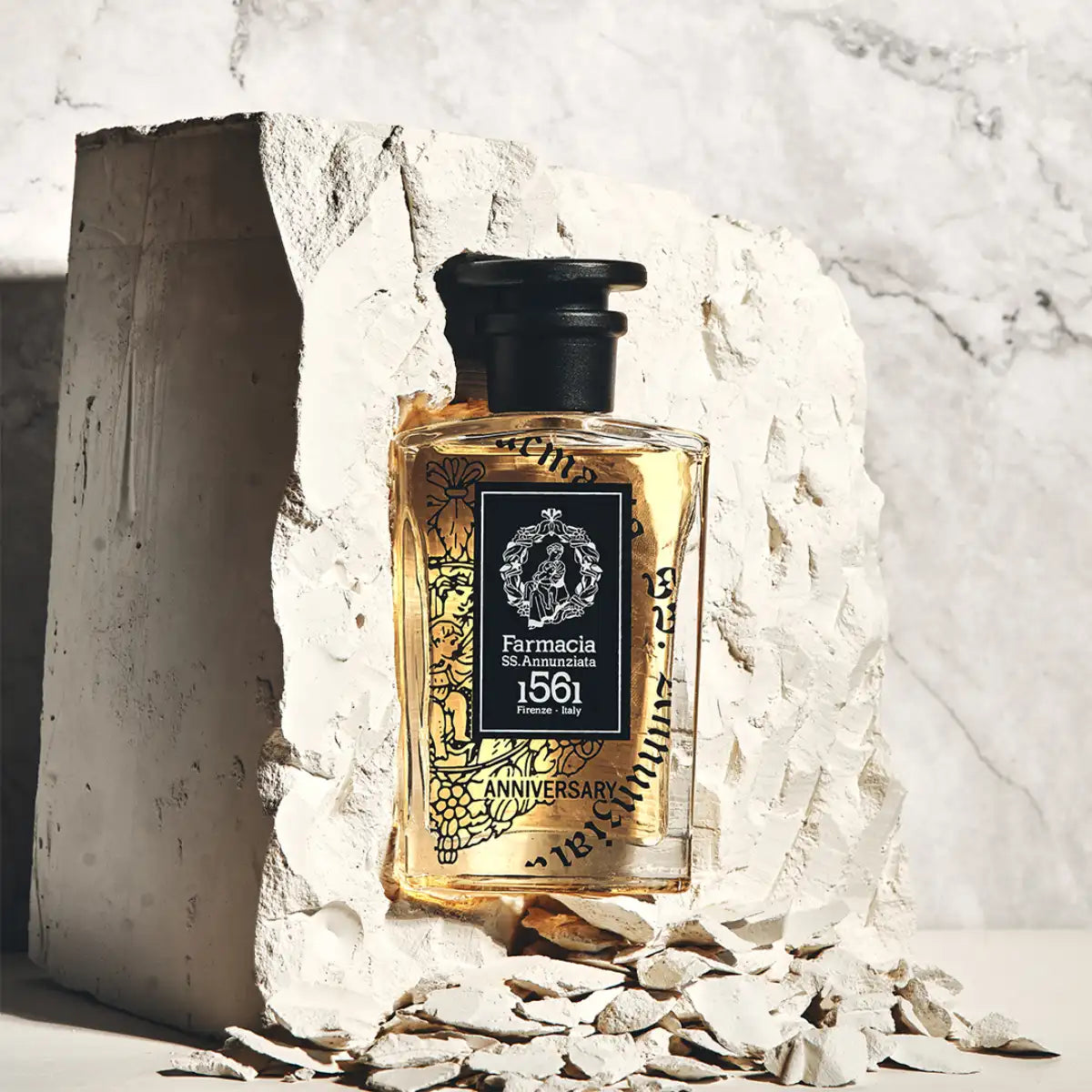 Farmacia SS. Annunziata - Anniversary Parfum mit bernsteinfarbener Flüssigkeit in kunstvoll gestaltetem Flakon vor hellem Hintergrund