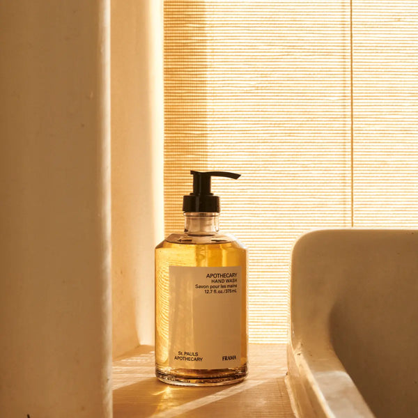 FRAMA - Apothecary - Hand Wash in klarem Spender mit schwarzem Pumpkopf in warmem, sonnendurchflutetem Badezimmerlicht