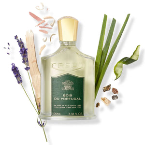 Creed - Bois du Portugal Parfumflakon mit grünem Label, goldfarbenem Verschluss und natürlichen Holz- und Kräuterelementen