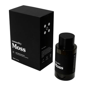 Commodity - Moss Parfumflakon mit schwarzer Verpackung in schlichtem, modernem Design auf weißem Hintergrund präsentiert