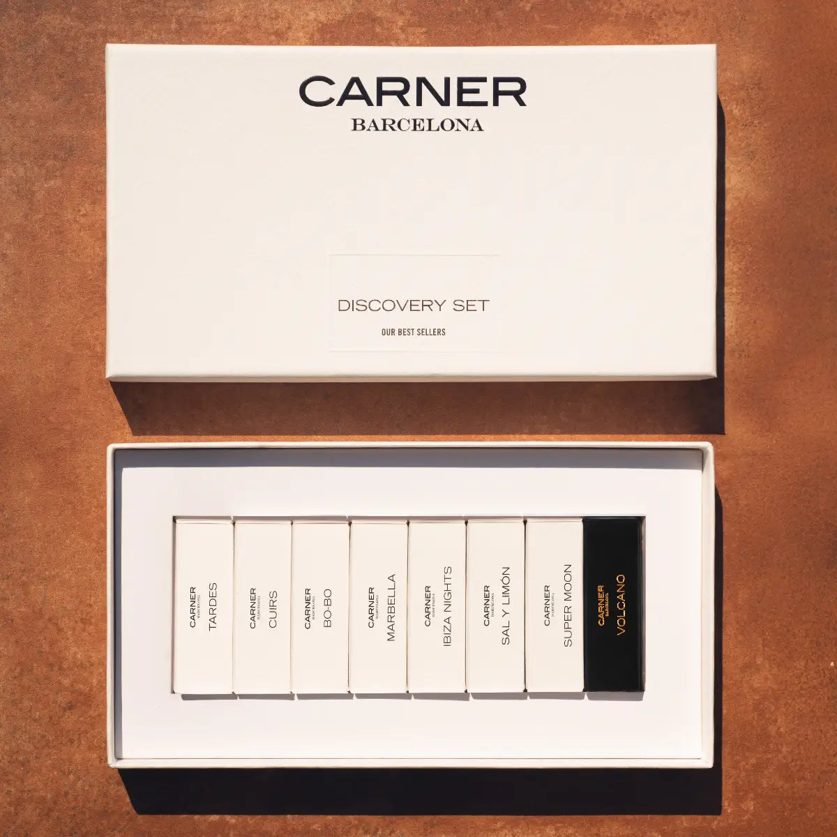 Carner Barcelona - Our Bestsellers Discovery Set mit neun Parfumproben in elegantem, weißem Präsentationsetui auf braunem Untergrund
