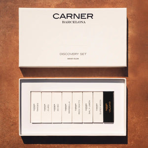 Carner Barcelona - Our Bestsellers Discovery Set mit neun Parfumproben in elegantem, weißem Präsentationsetui auf braunem Untergrund
