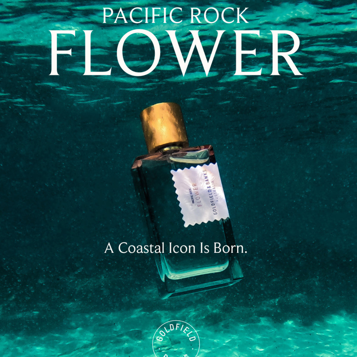 Goldfield & Banks - Pacific Rock Flower Parfumflakon mit goldenem Verschluss in klarem Wasser vor aquatischem Hintergrund