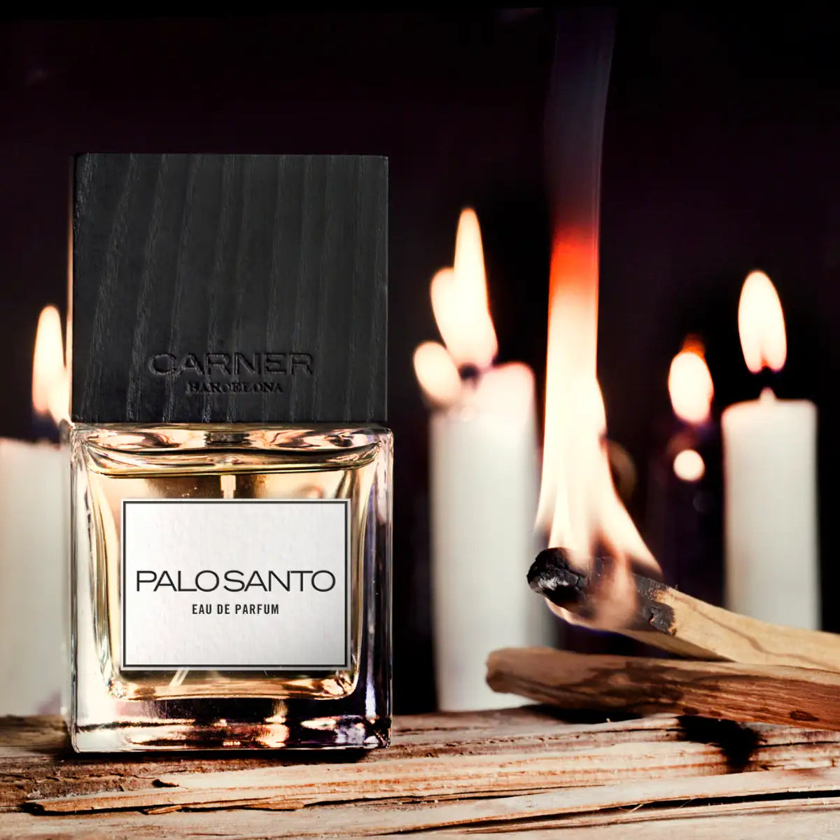 Carner Barcelona - Palo Santo Parfümflakon mit schwarzem Holzdeckel vor brennendem Palo Santo und Kerzenlicht