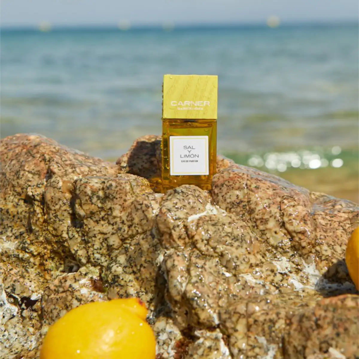 Carner Barcelona - Summer Journey Collection - Sal Y Limón Parfum in sonnigem Gelb auf felsiger Küste am Meer