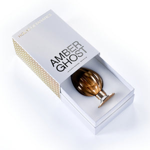 House of Fanatics - Amber Ghost zeigt eleganten bernsteinfarbenen Flakon mit goldfarbenem Sockel in edler Geschenkbox