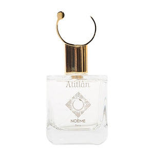 Noème Paris - Atitlàn Parfumflakon mit klarem Glas und goldenem Verschluss vor weißem Hintergrund