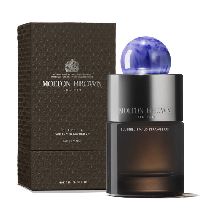 Molton Brown - Bluebell & Wild Strawberry zeigt eleganten Flakon mit dunkel getöntem Glas und blauer Kugelkappe neben Verpackung