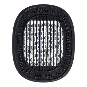 Diptyque - 34 Boulevard Saint Germain - Capsule mit schwarzem Rahmen und duftenden Perlen hinter vertikalen Streben sichtbar
