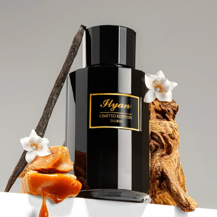 Imperial Parfums - Ilyan Flakon in schwarz mit goldener Schrift, umgeben von Vanilleblüten und Holzstil – luxuriös inszeniert