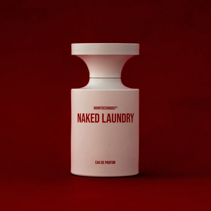 BORNTOSTANDOUT - Naked Laundry eleganter weißer Flakon mit markanter roter Schrift vor tiefrotem Hintergrund minimalistisch gestaltet
